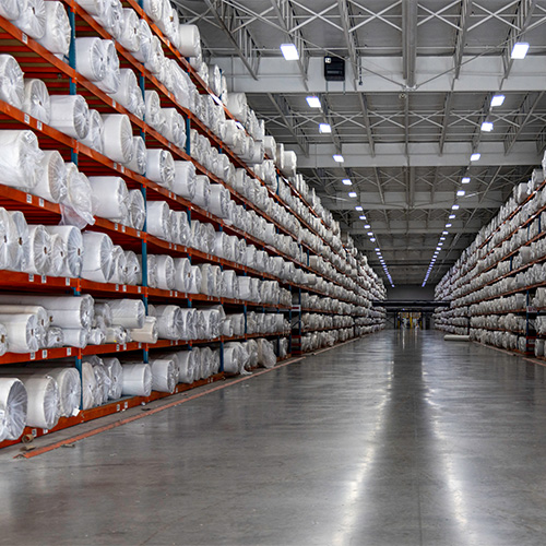 Rows of flooring products stored in a large distribution warehouse.